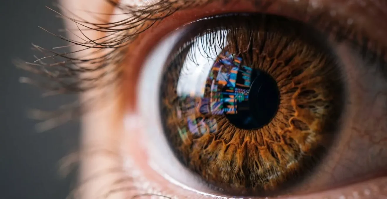 Vue macro d'un œil humain reflétant des éléments visuels abstraits suggérant une surcharge d'information