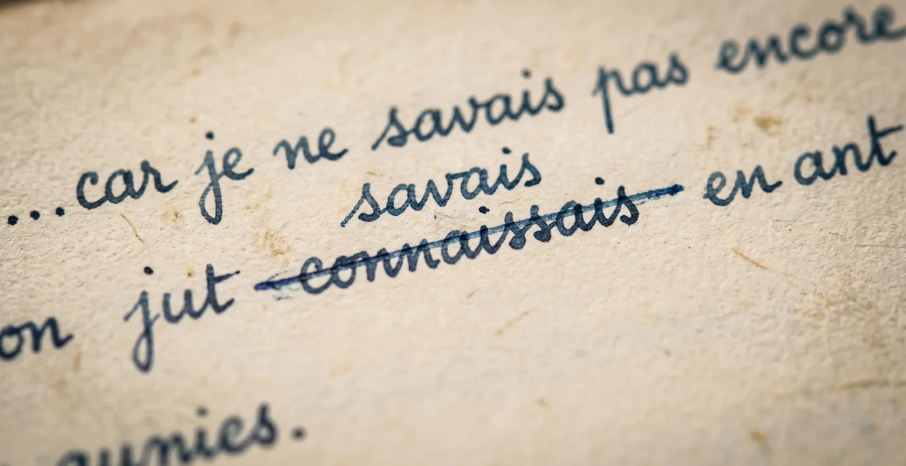 Macro détail d'une ligne manuscrite de Boris Vian montrant un mot barré à l'encre bleue et son remplacement écrit au-dessus en plus petit.